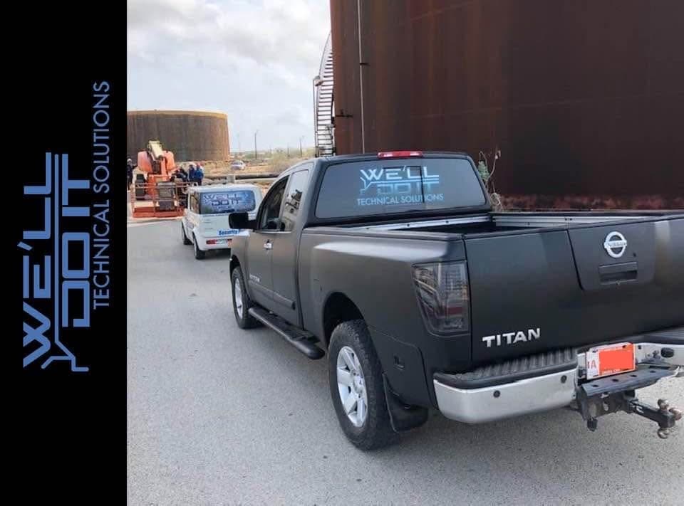 We'll Do It vehicles in an industrial environment with license plates redacted